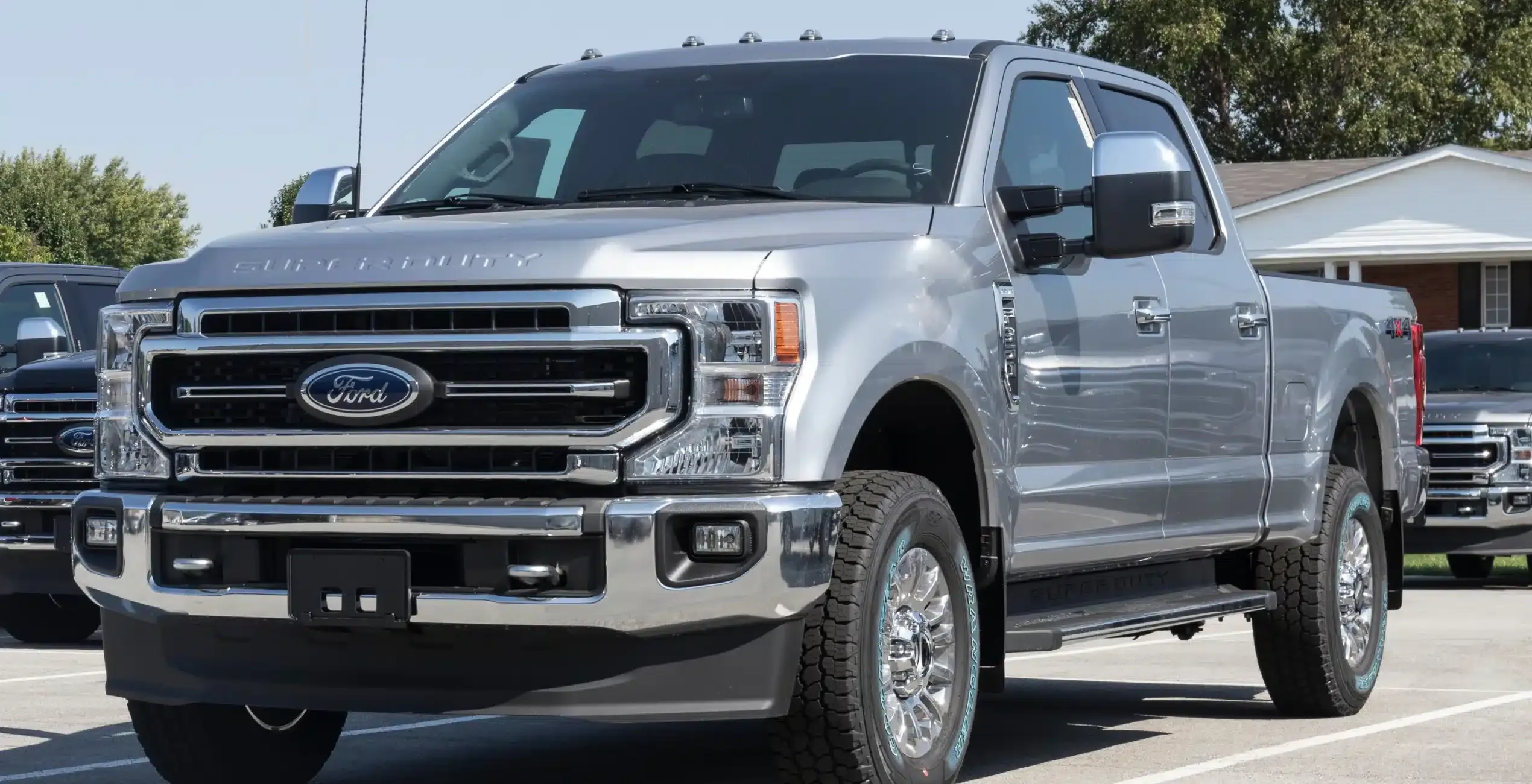 1023 Diesel & Fleet: a silver Ford Super Duty pickup truck with a bold grille parked on a paved surface near a residential area.